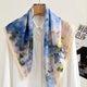 Blue floral silk neckerchief with pale lace trim draped over a white shirt.