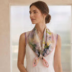 Pale floral silk neckerchief with lilac lace trim tied over a white top.