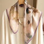 Cream and brown leaf-print silk neckerchief with purple lace trim draped over a white shirt.