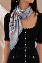 Blue and lilac landscape silk neckerchief with blue lace trim worn over a black dress.