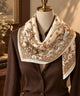 Ivory and camel paisley silk scarf draped around a mannequin's neck.
