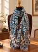 Teal-blue lily-of-the-valley silk wool scarf draped around a mannequin over a burgundy jacket.